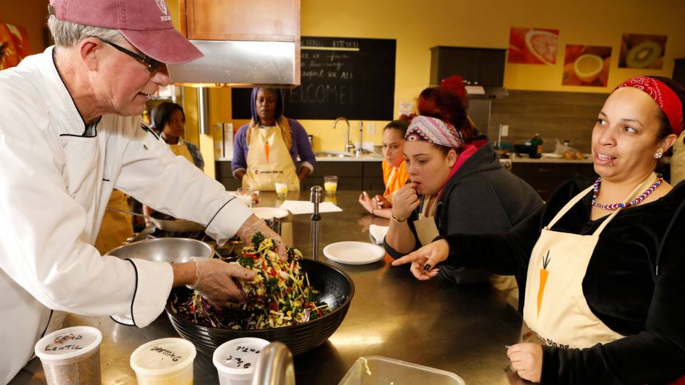 Alexander Trimble showing HomeFront clients how to make meals