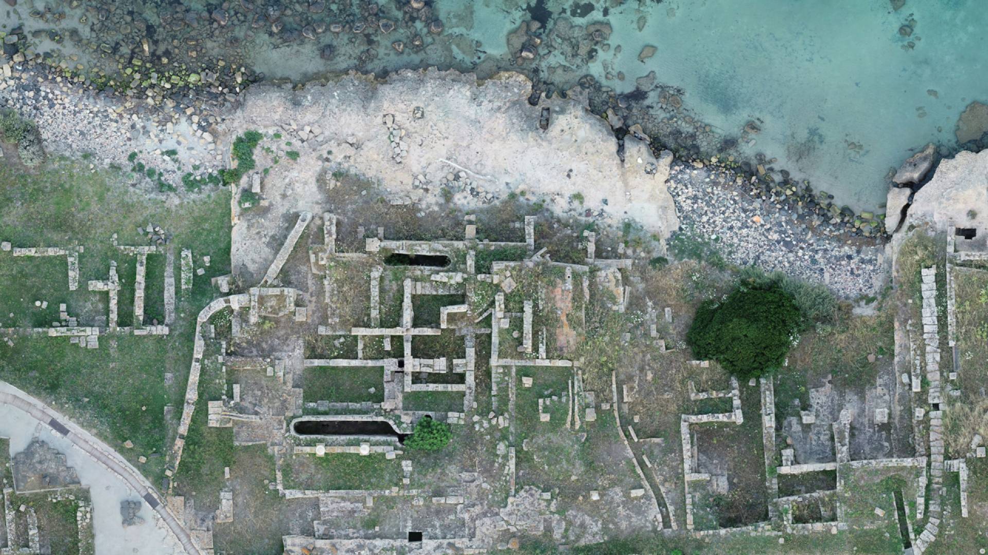 View of a field with remnants of a structure from high above.