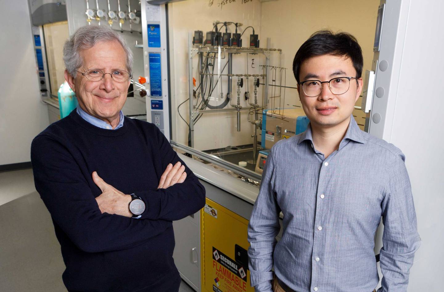 Two researchers in their lab full of equipment