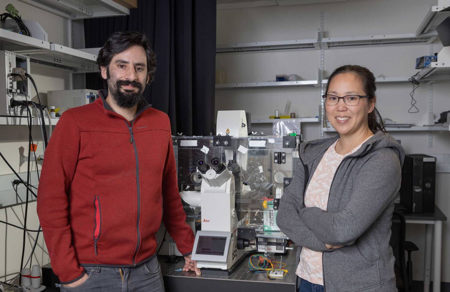 Two researchers in their lab full of equipment