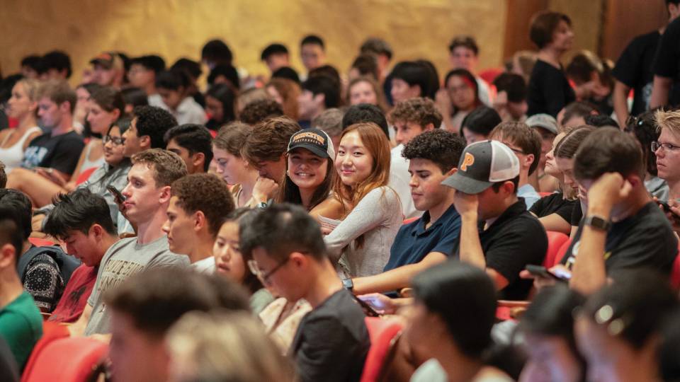 A crowd with 2 individuals smiling.
