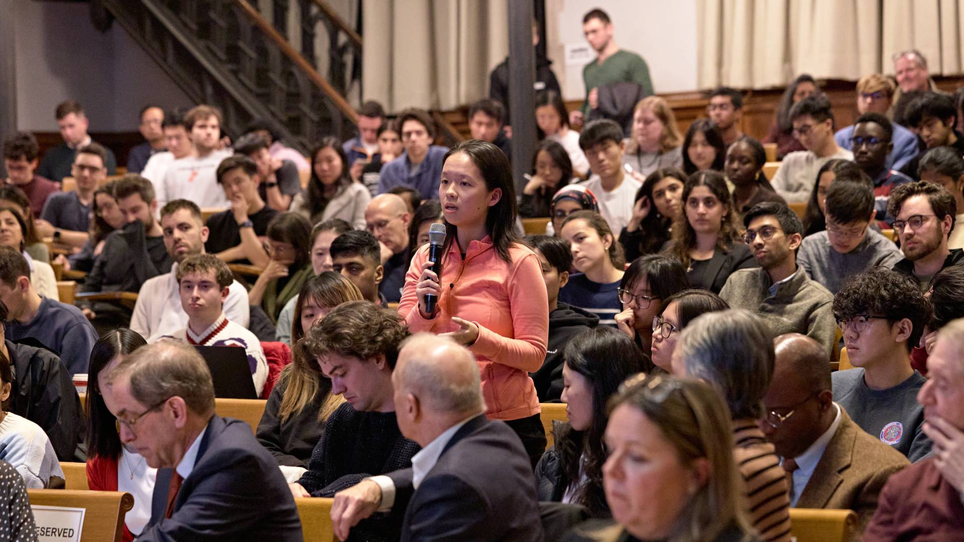 A student asks a question into a microphone