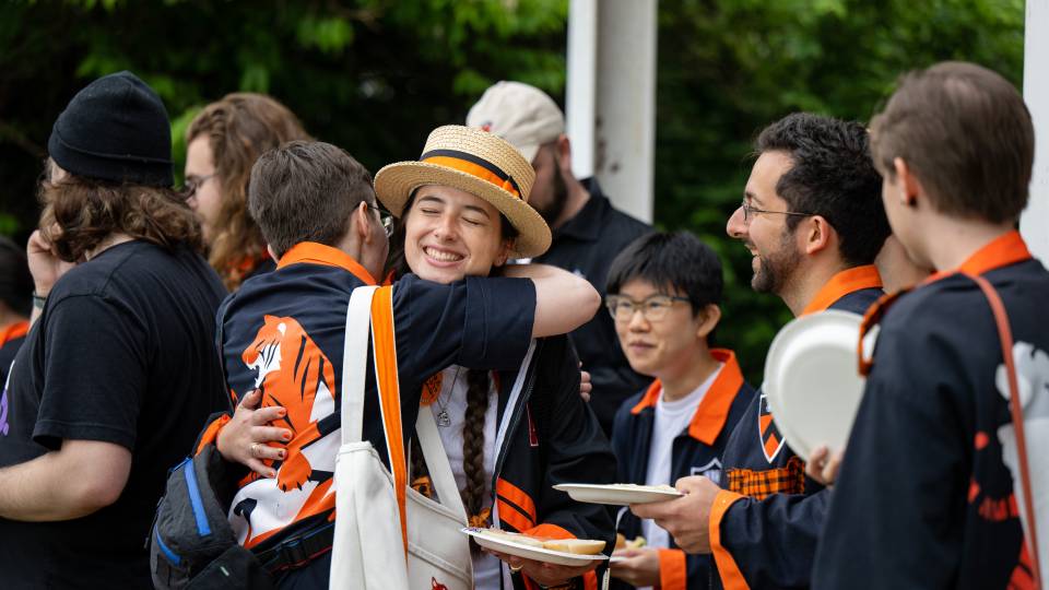 Alumni hugging one another